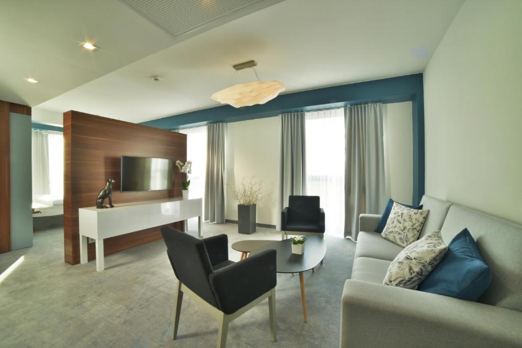 ein Wohnzimmer mit einem Sofa und einem Schreibtisch in der Unterkunft Focus Hotel Premium Lublin Conference & SPA in Lublin