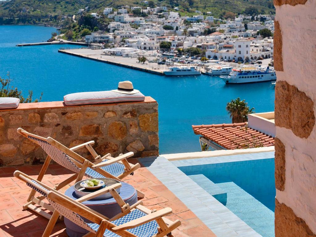 a patio with chairs and a view of a harbor at Patmos Eye Boutique Hotel & Villas in Skala