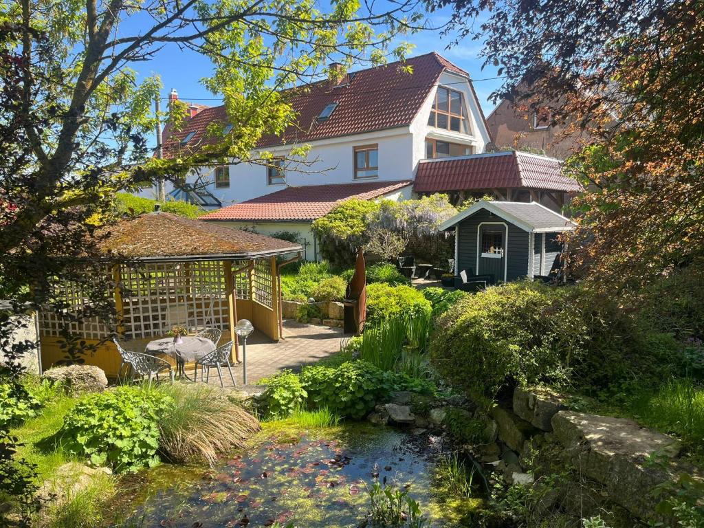 a house with a garden with a stream in front of it at Lieblingsplatz Appartement in Seelitz