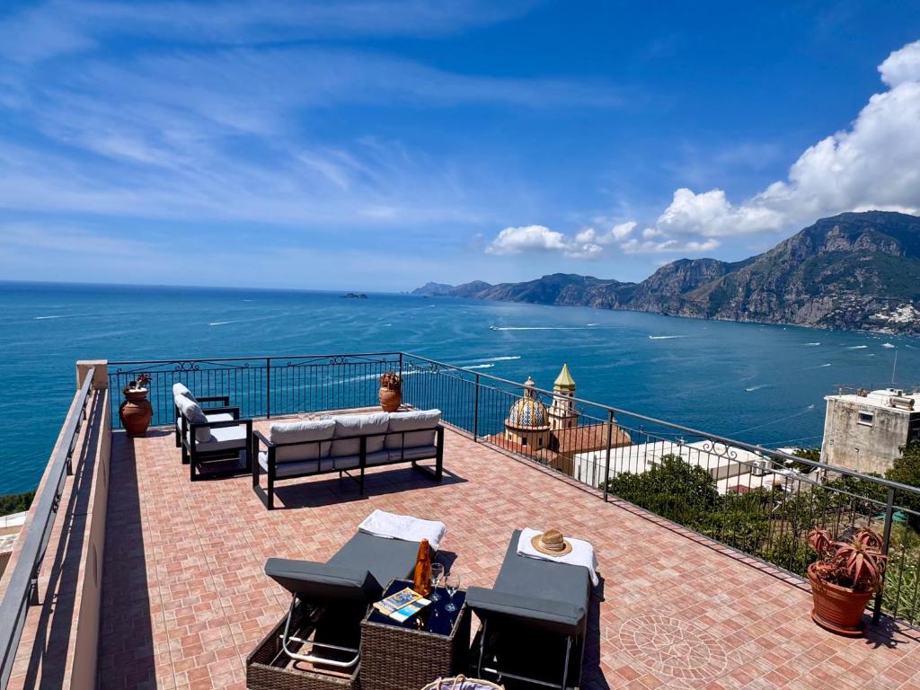 a balcony with chairs and a view of the ocean at Villa Giardino Eden in Praiano