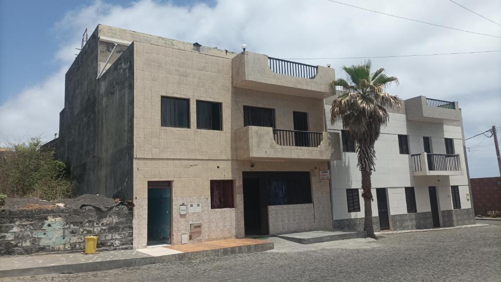 a building with a palm tree in front of it at Gira Lua in Igreja