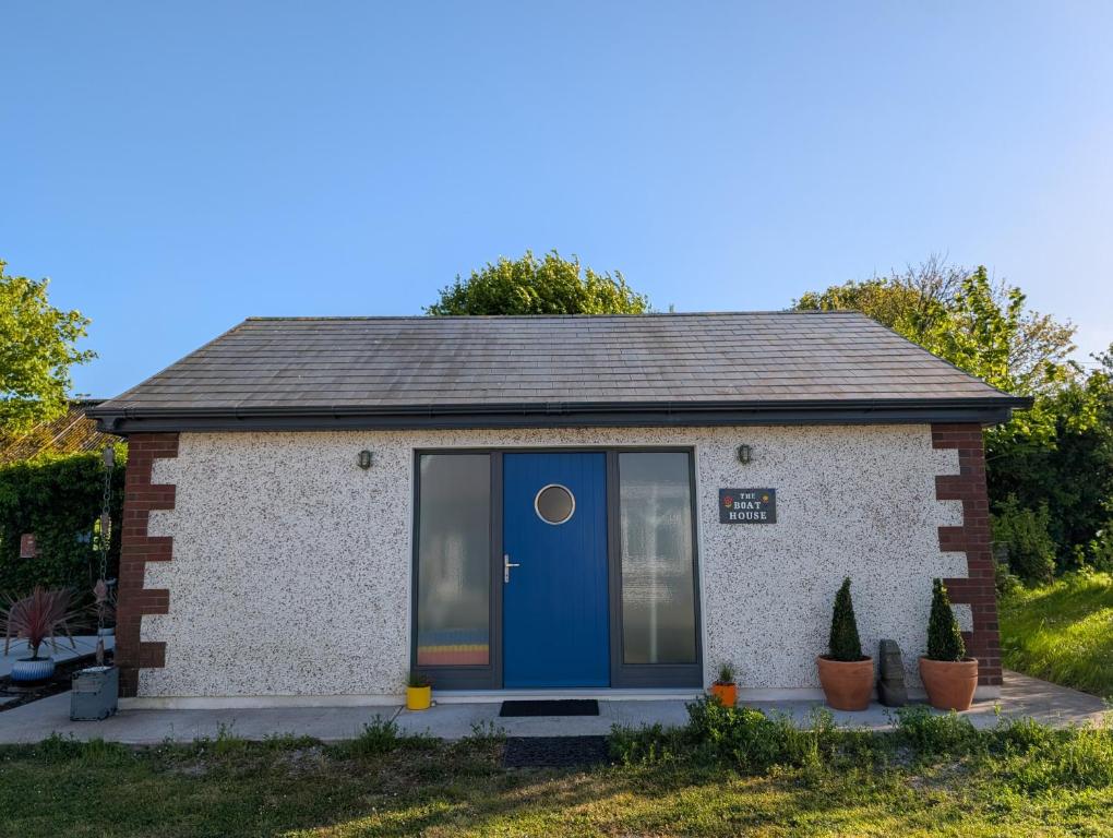 a small brick building with a blue door at The Boathouse in Ballycotton