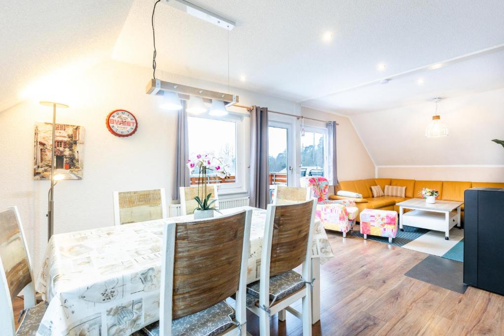 a dining room and living room with a table and chairs at Ferienwohnung Frankenblick in Frankenau