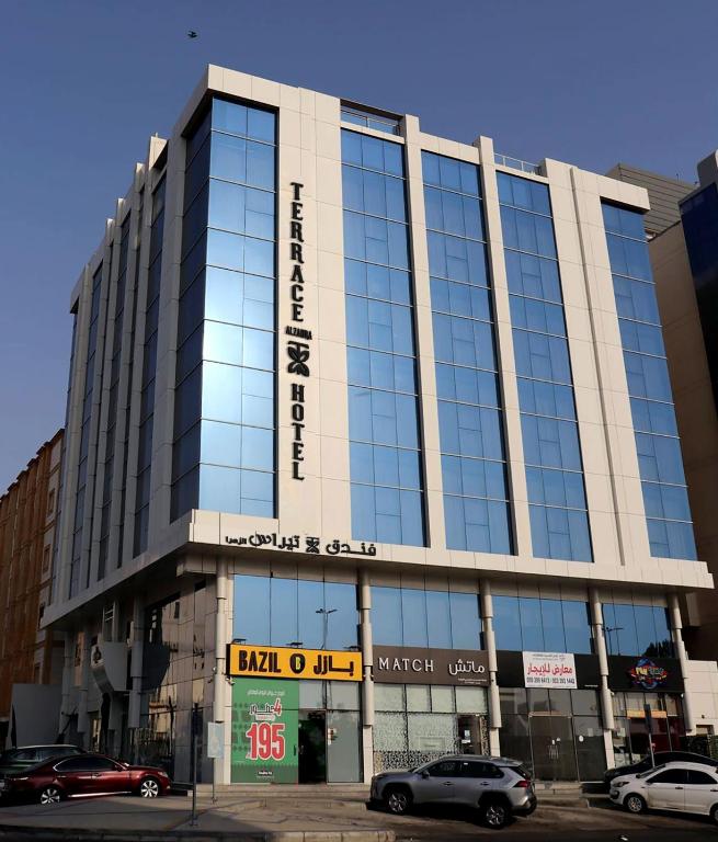 a large building with glass windows on a street at Terrace Alzahra تيراس الزهرا in Jeddah