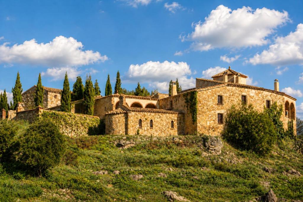 an old castle on a hill with trees at Fortaleza Medieval La Manyosa in Granera
