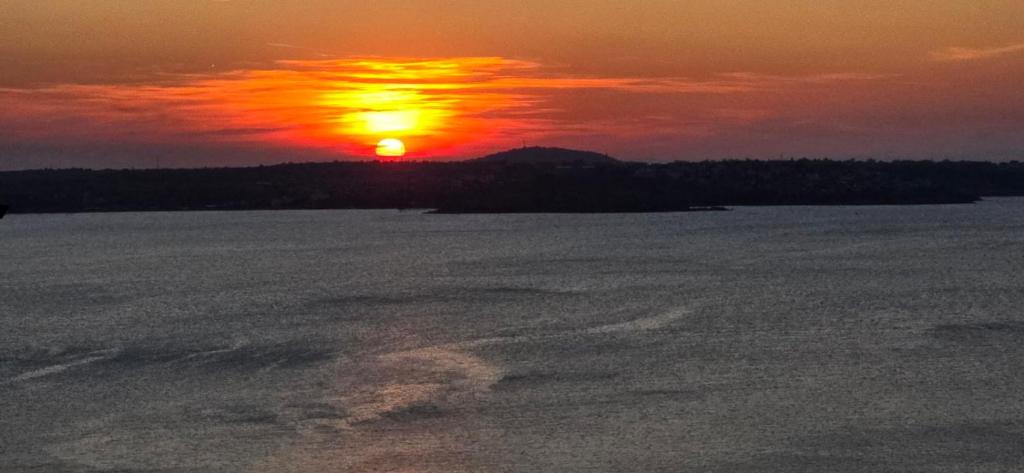 a sunset over a large body of water at ORION Guest House in Sozopol