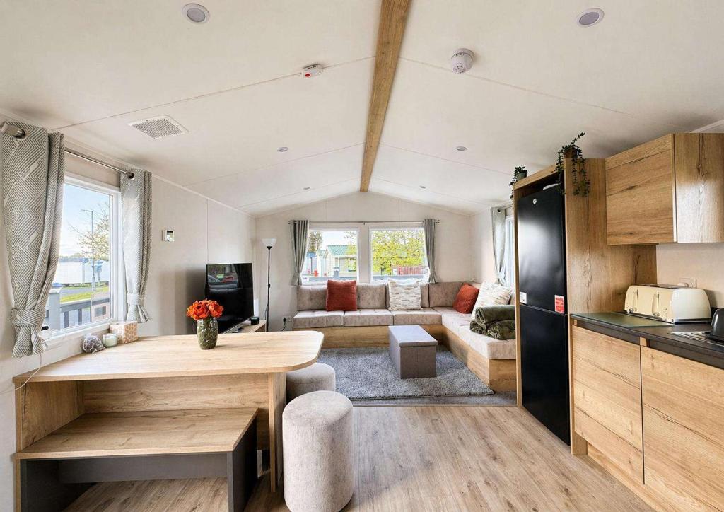 a kitchen and living room with a table in a caravan at Kestrel Court 16 in Scratby