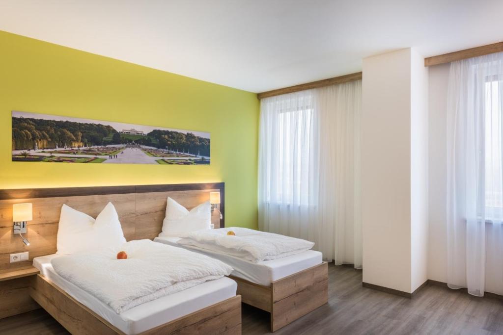 Loosdorf的住宿－Sleepin Premium Motel Loosdorf，一间卧室设有两张床,墙上挂着一幅画
