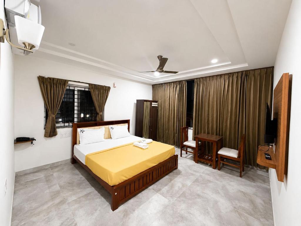 a bedroom with a bed and a television in it at Nakshatra Boarding and Lodging in Mangalore International
