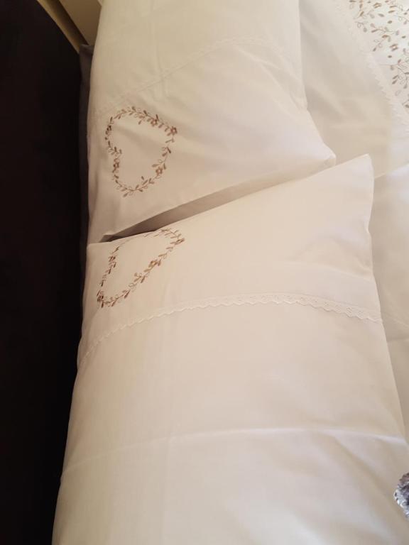 Una almohada blanca con un corazón bordado en ella en The Snug at Plover Cottage Lindley en Huddersfield