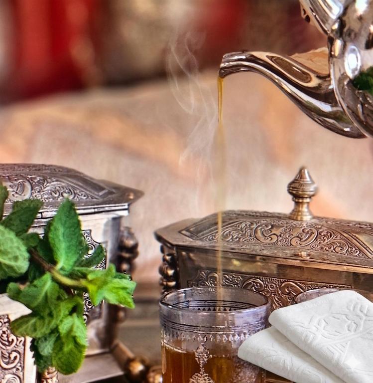 a tea kettle pouring tea into a glass at Villa Majlis in Marrakesh