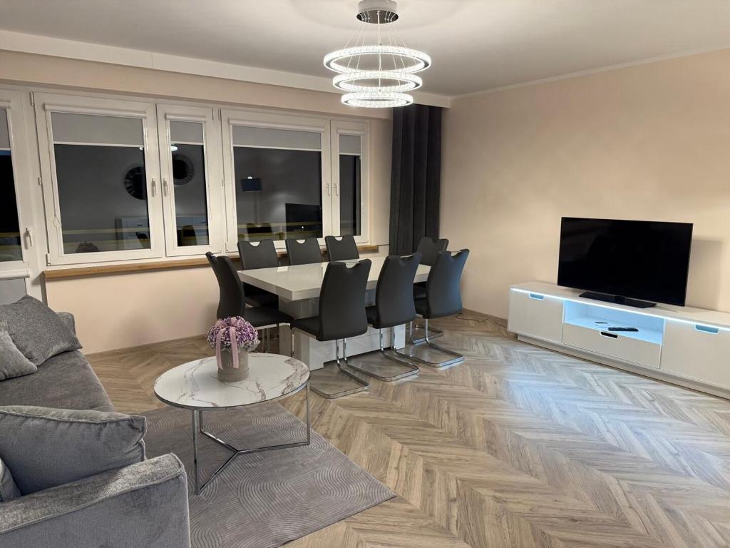 a living room with a table and chairs and a television at Urban Relax AC Progres in Toruń