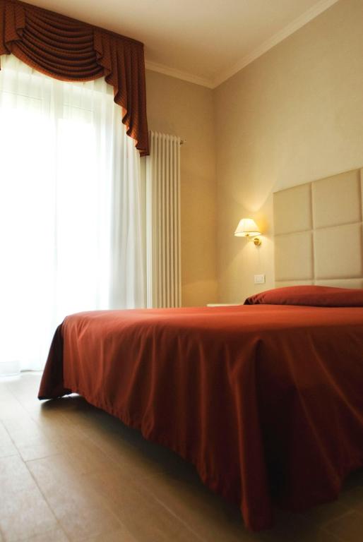 Postel nebo postele na pokoji v ubytování Hotel Gradara