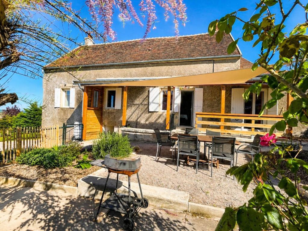 a house with a grill in front of it at La ferme Bourguignonne in Saizy