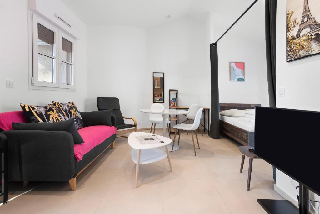 a living room with a couch and a bed at Appartement Moderne 1 à Fréjus in Fréjus