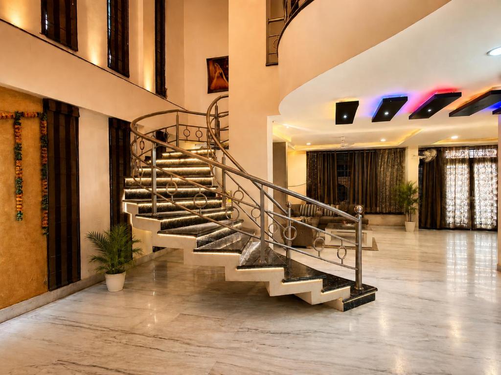a metal spiral staircase in a lobby at Urbana Luxury AC Duplex Bungalow with Pergola Terrace in Nagpur
