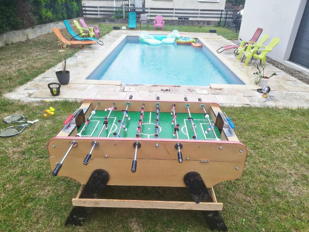 a pool with a playing table in the grass at Éclipse in Vénissieux
