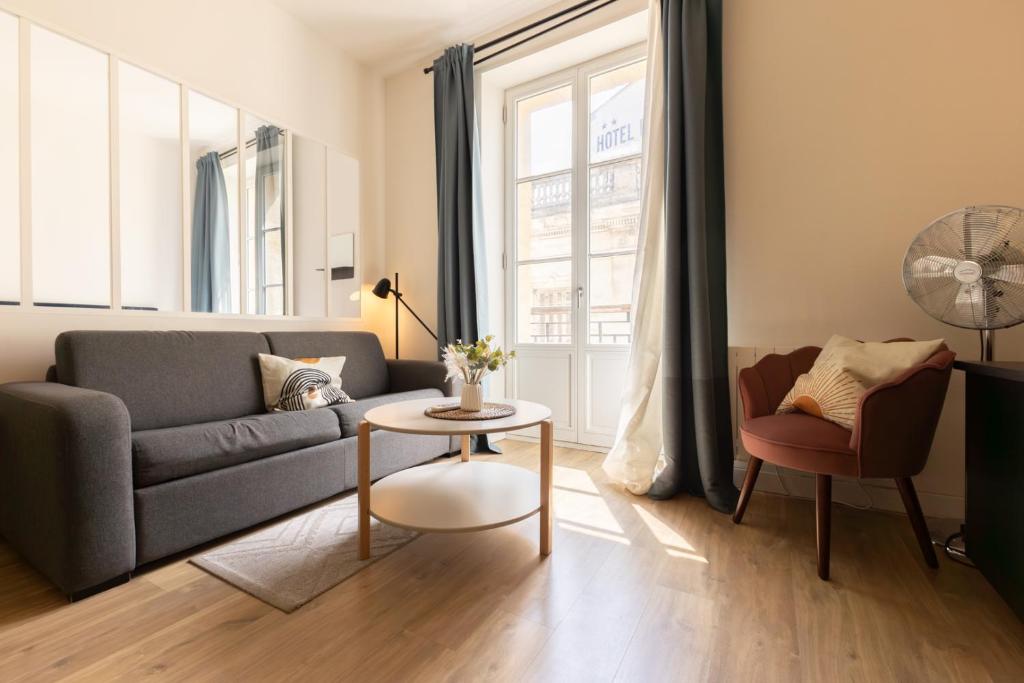 a living room with a couch and a table at Magnifiques Appartements - Face a la Gare in Bordeaux