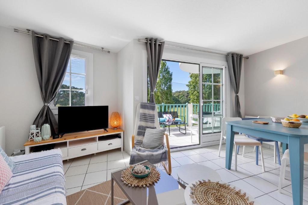 a living room with a tv and a table at La Terrasse du Golf Bourgenay in Talmont