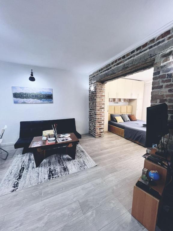 a living room with a couch and a bed at OM Center Apartments Tirana in Tirana