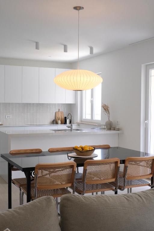 a kitchen with a table with chairs and a dining room at Apartment Maestral, Pucisca ,Island Brac in Pučišća