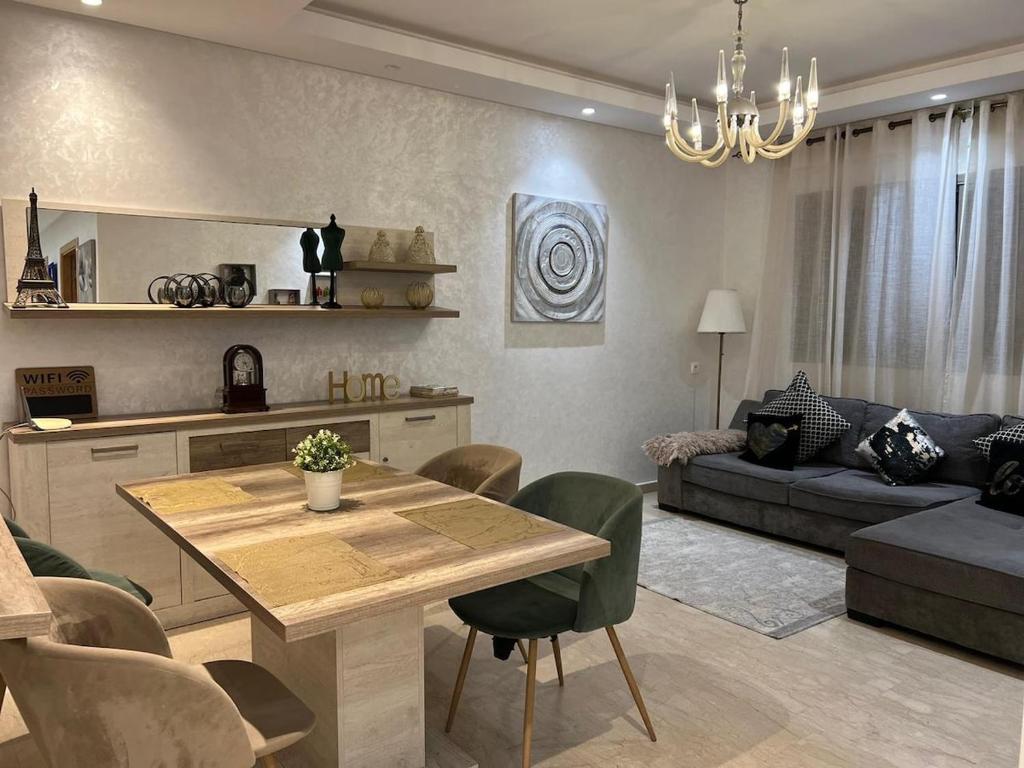 ein Wohnzimmer mit einem Tisch und einem Sofa in der Unterkunft infinity by Hadil-Rabat centre ville in Rabat