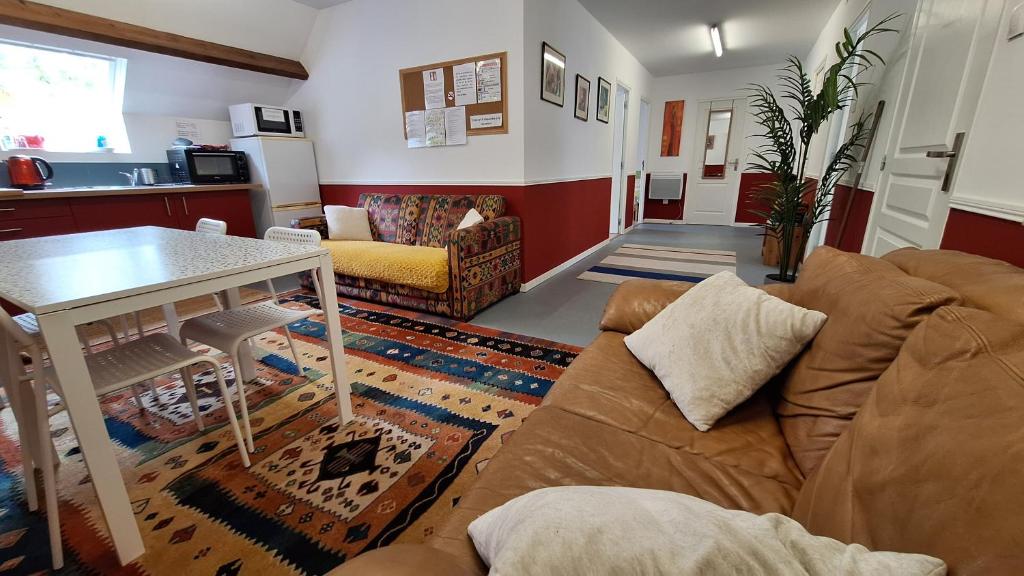 a living room with a couch and a table at Appartement Privé, Camping La Pointe in Châteaulin