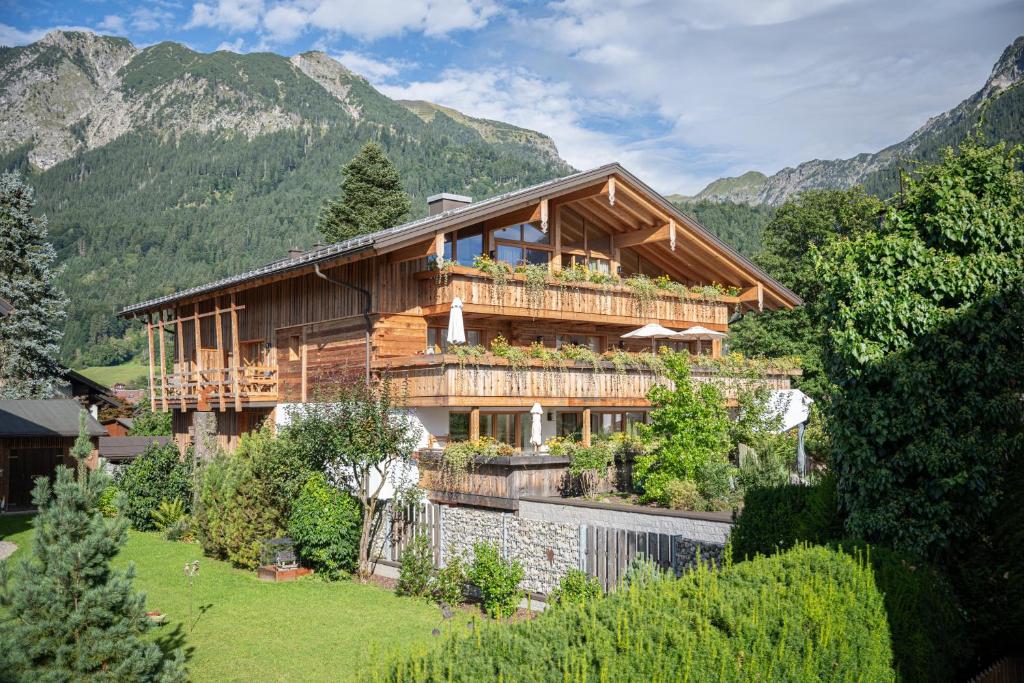 a wooden house in the mountains with a yard at Landhaus Wiederkehr in Oberstdorf