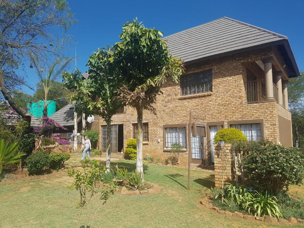 a brick house with a tree in front of it at Big Boma Guest House in Lydenburg
