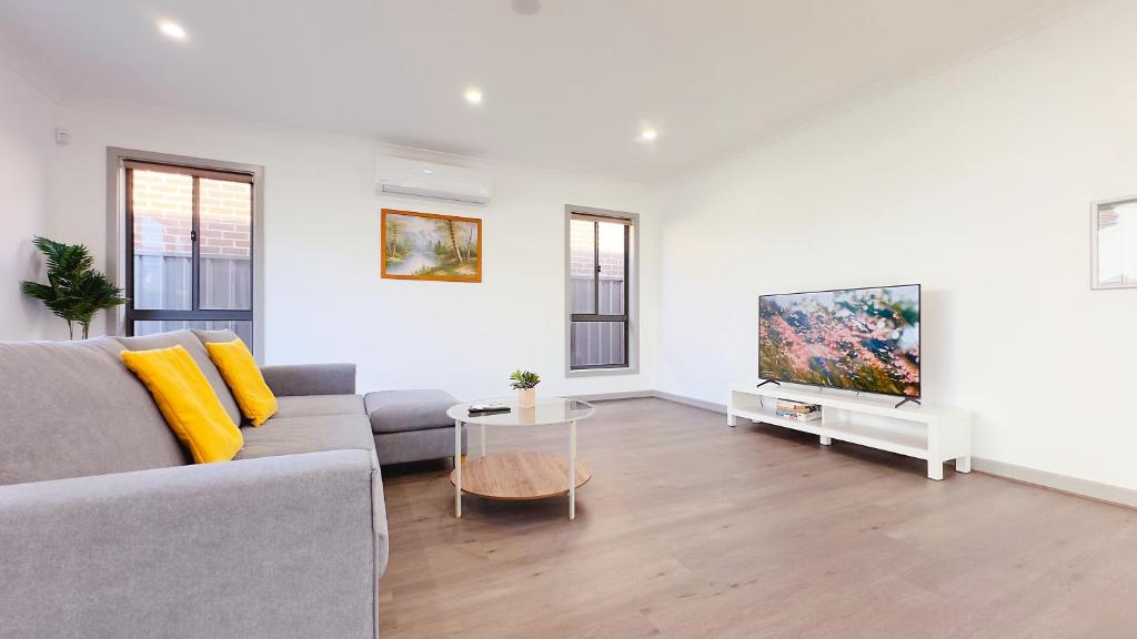 a living room with a couch and a flat screen tv at Evergreen 3B Home by Goodlive in Clyde