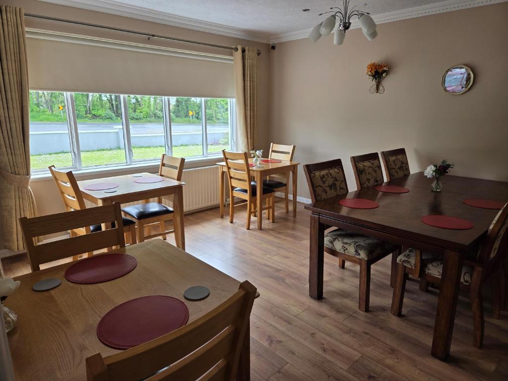 a dining room with tables and chairs and a window at Lilac Manor in Sligo