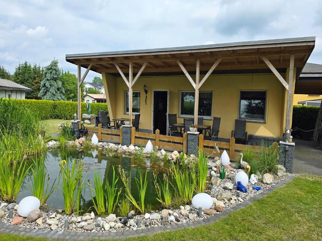a house with a pond in the yard at Ferienhaus am Wiesengrund in Sagard