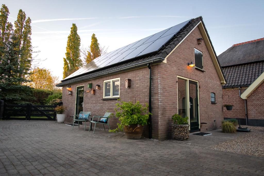 a house with solar panels on the roof at B&B Oud-Zilven Het Vogelhuisje in Loenen