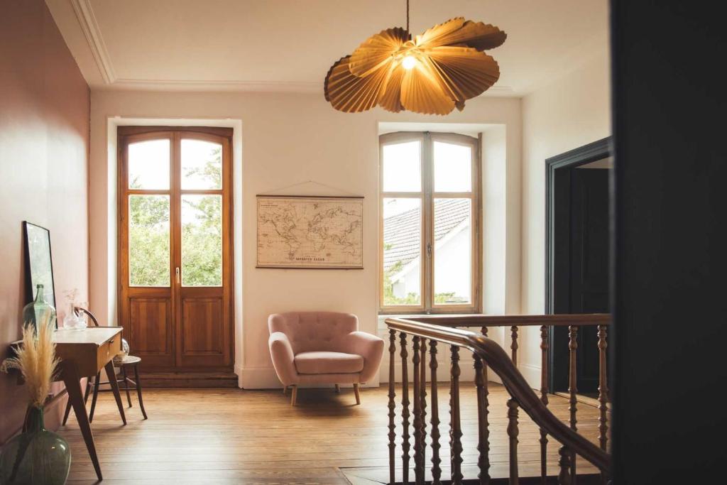 a living room with a chair and a chandelier at Le Studio 3 - Route des vins in Rorschwihr