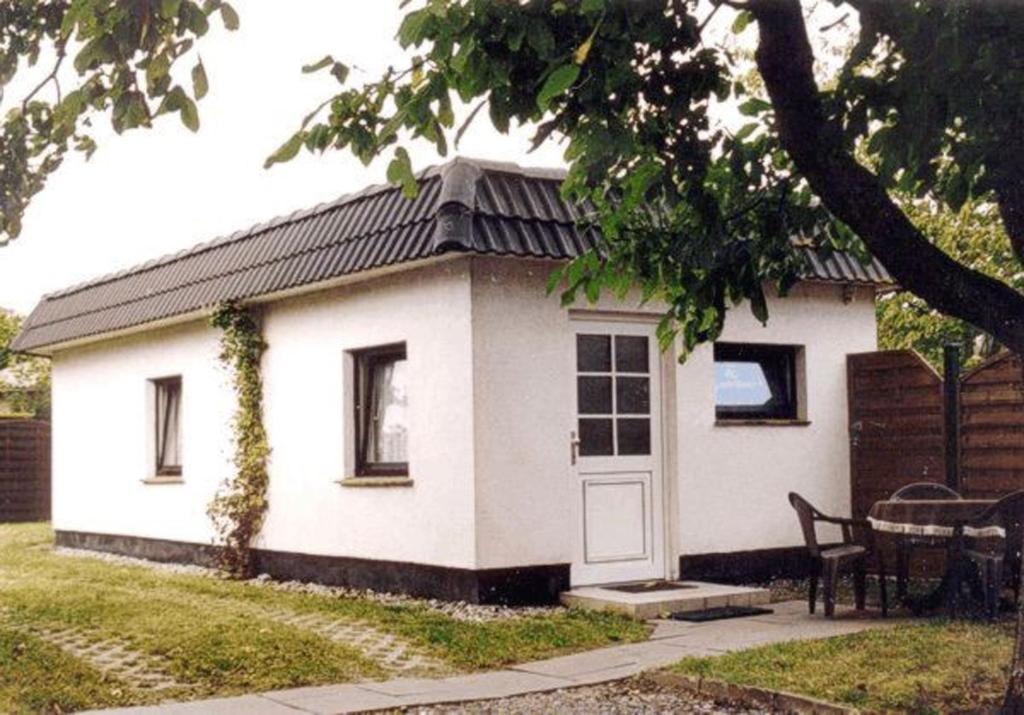 a small white house with a table in a yard at Ferienhaus Karger in Sagard