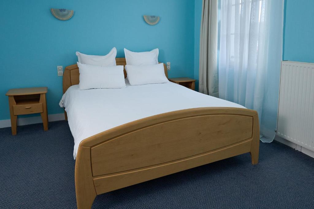 a large bed in a room with blue walls at Hôtel Restaurant Le Plat d'Etain in Brou