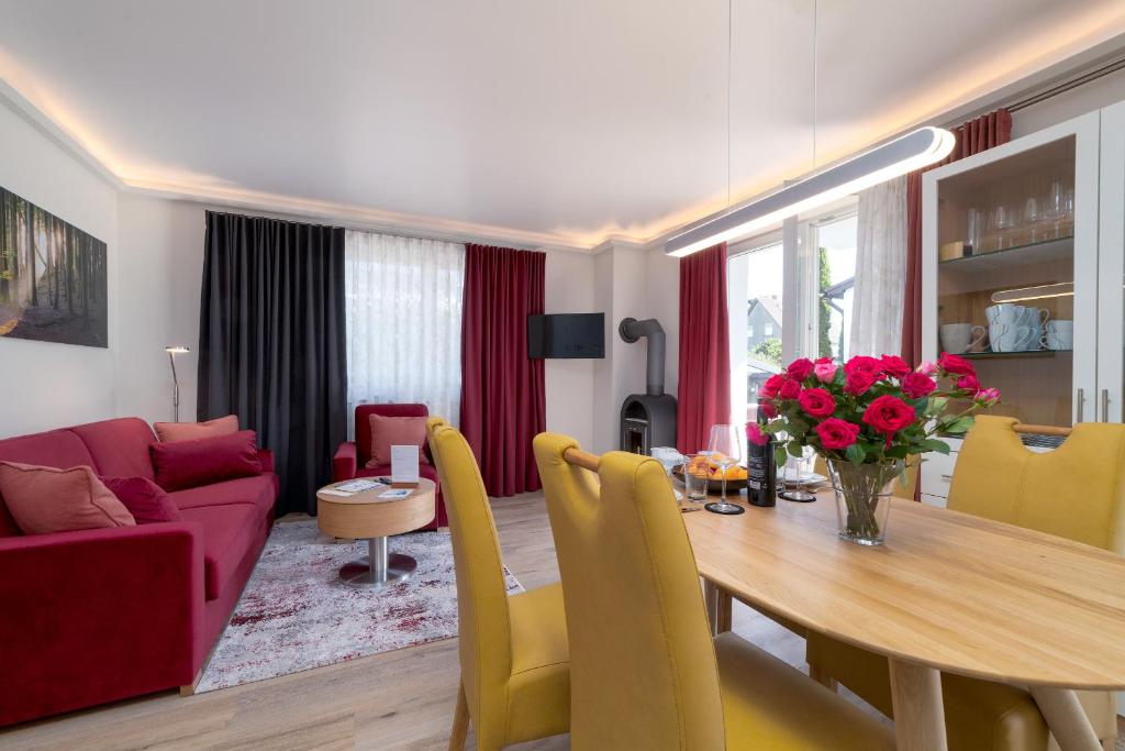 a dining room and living room with a table and a couch at Villa Nause-FeWo Buchenfreund mit Spa und Freizeit in Sassnitz