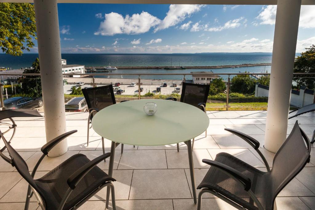 a table and chairs on a balcony with a view of the ocean at Villa Friede Marie FeWo Ariane in Sassnitz