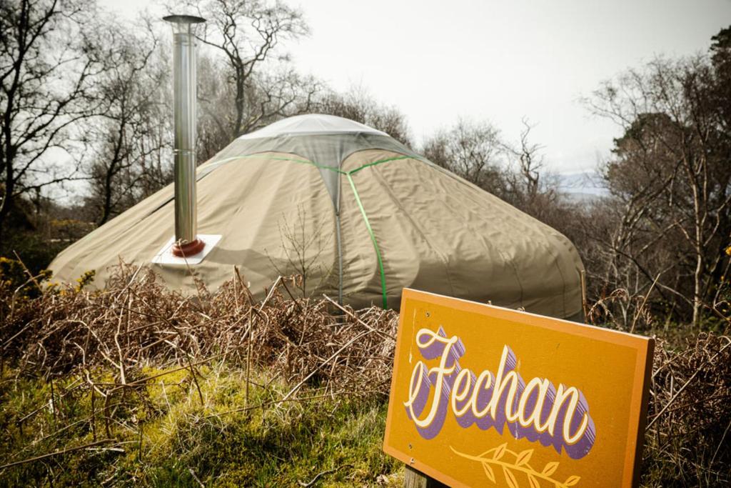 a sign in front of a tent in a field at Kelburn Yurts - Fechan in Fairlie