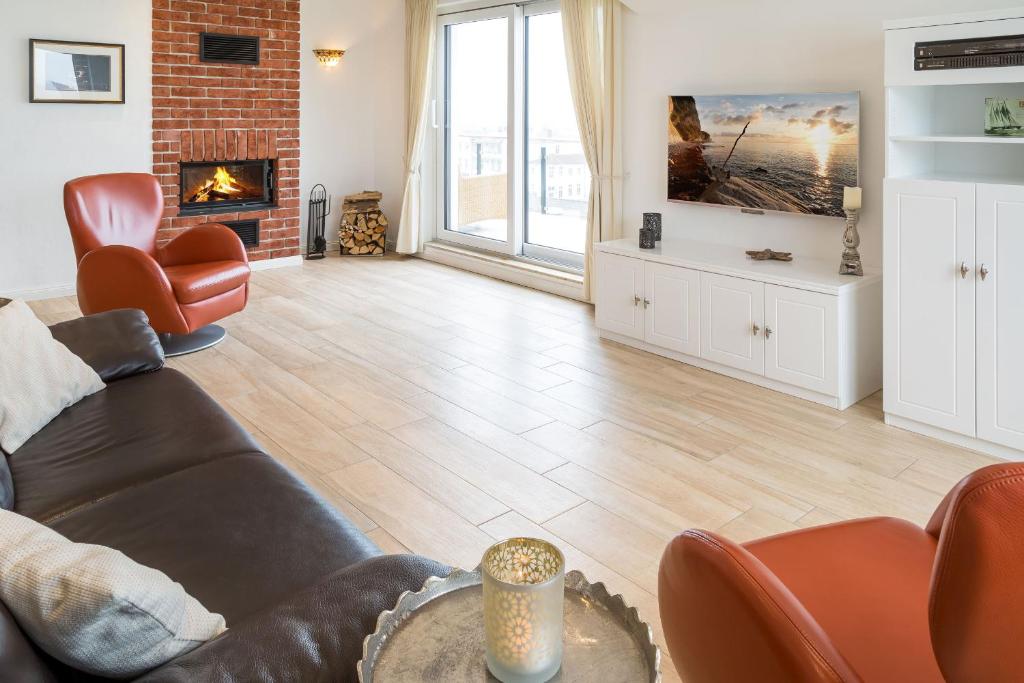 a living room with a couch and a fireplace at Villa am Kreidebruch - Ostseeweitblick in Sassnitz