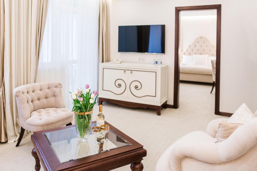 a living room with a television and a table with flowers at Galant Hotel in Truskavets