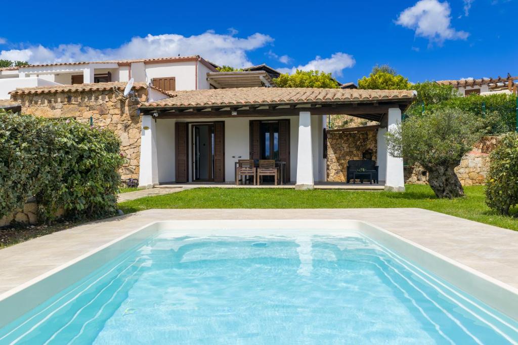a swimming pool in front of a house at Casa della Luna con piscina in Budoni