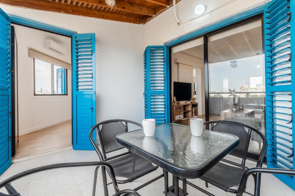 a table and chairs on a balcony with a television at Beachside Hideaway Apartment, 200m to the Havana Beach in Pyla
