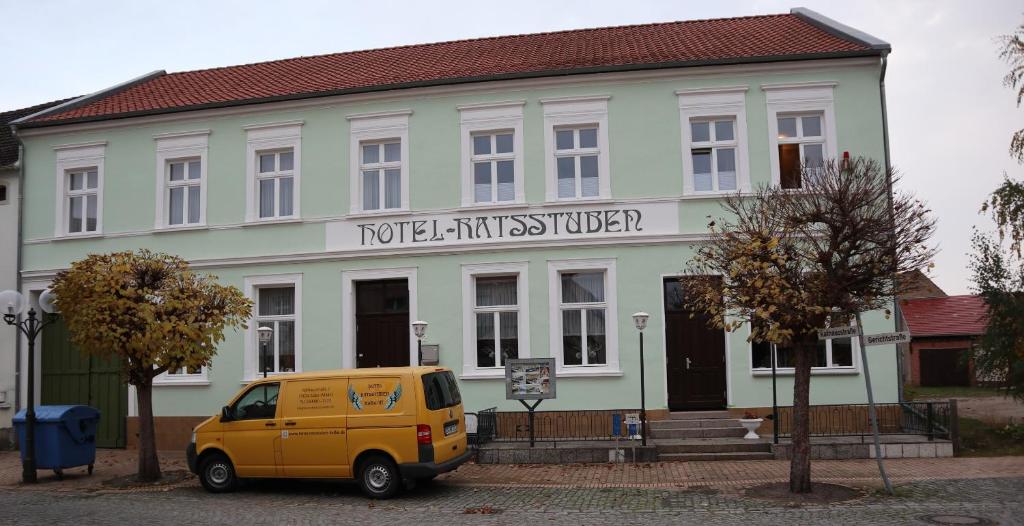 a yellow van parked in front of a building at Hotel Ratsstuben Kalbe in Kalbe