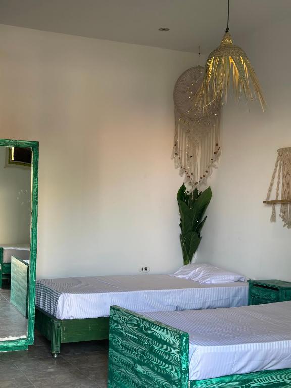 two twin beds in a room with a mirror at Studio In DaHaB in Dahab