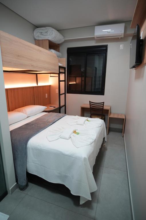 ein Schlafzimmer mit einem großen Bett mit weißer Bettwäsche in der Unterkunft Hotel Pandolfi in Dois Vizinhos