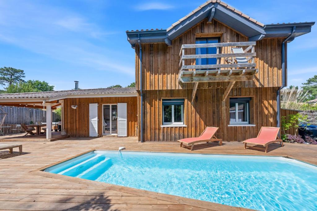 a house with a swimming pool in front of a house at Villa typique - piscine et terrasse in La Teste-de-Buch