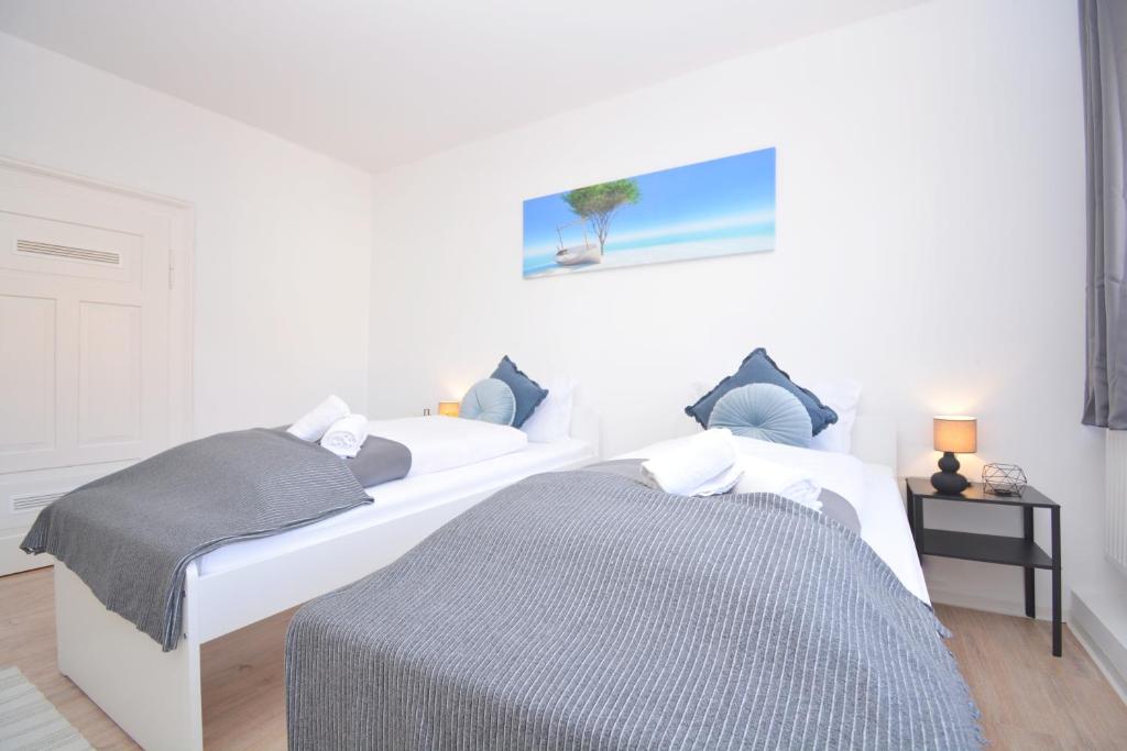 two beds in a room with white walls at Apartments in Ebrach am Kloster in Ebrach