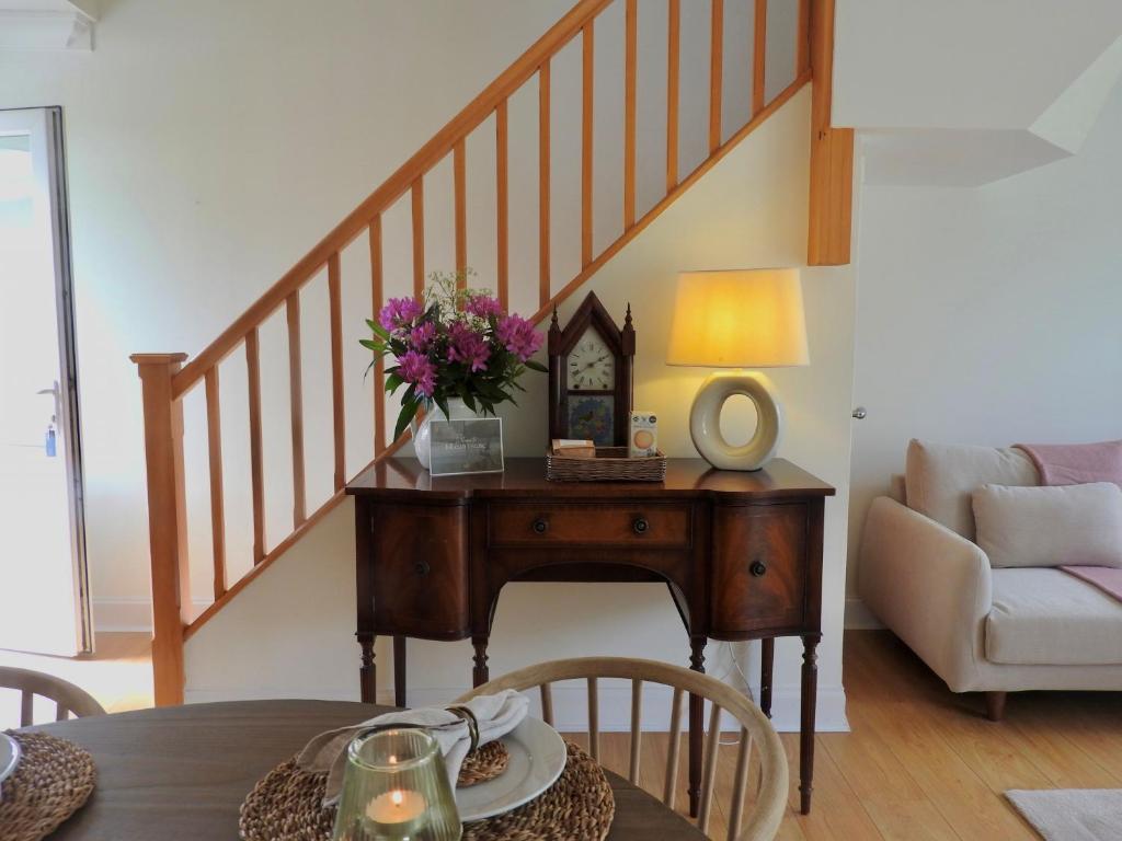 a living room with a table with flowers on it at Foxglove Cottage in Killean