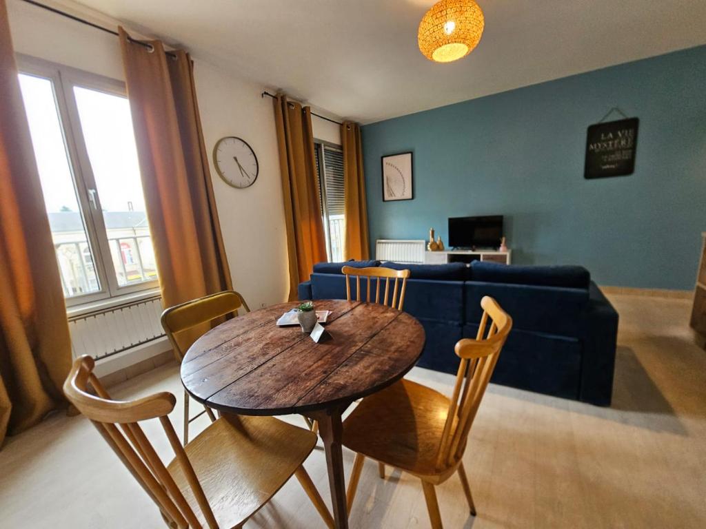 a living room with a table and a couch at Quai de la Gare, Appartement étape, 2 chambres, face à la Gare in Châtellerault